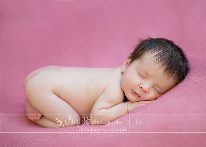 Newborn baby girl on a pink blanket