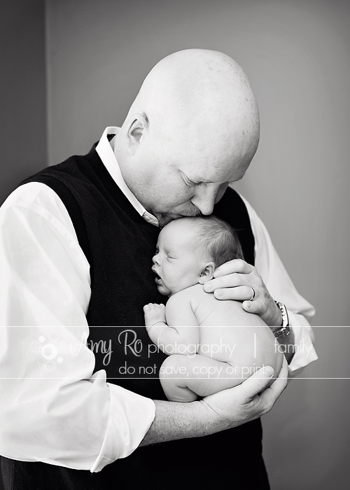 Newborn baby with her father kissing her