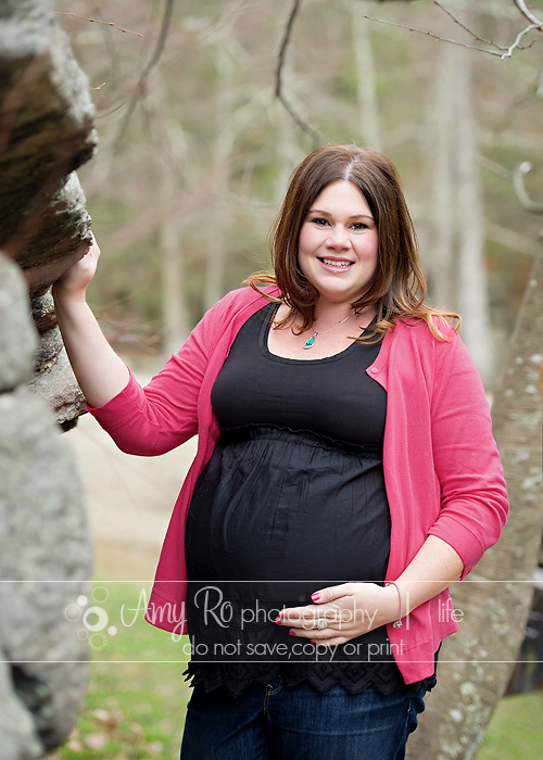 Pink maternity sweater posing with rocks
