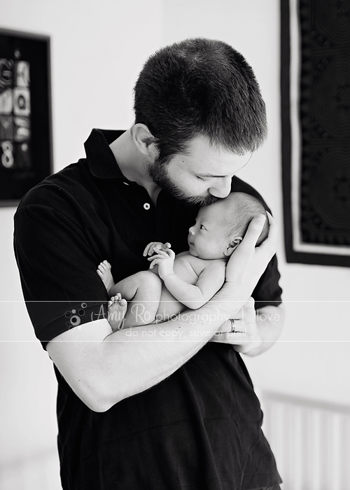 Father kissing newborn baby girl