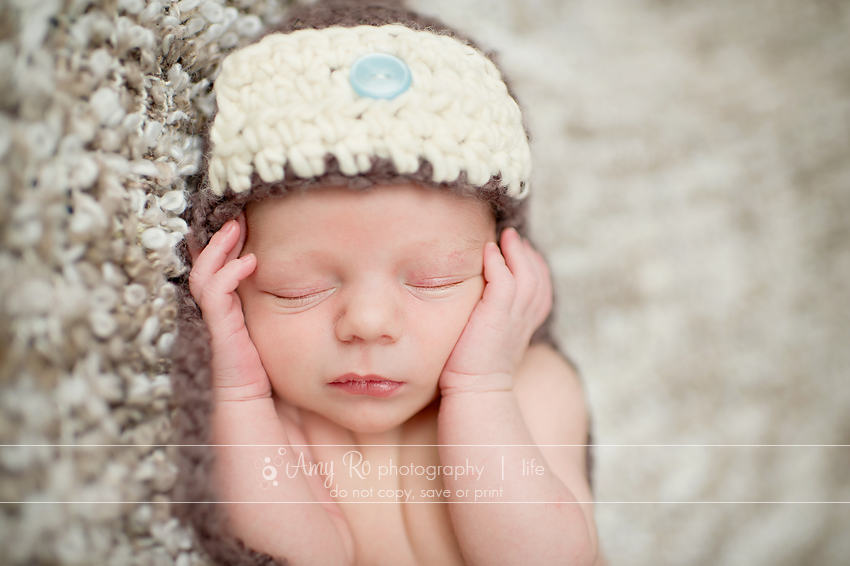 Newborn on tan and cream blanket