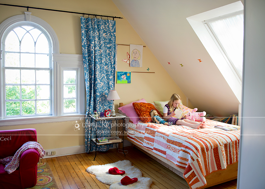 Portrait of a little girl reading in her room