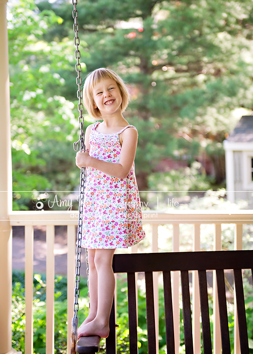 Little girl on a porch swing