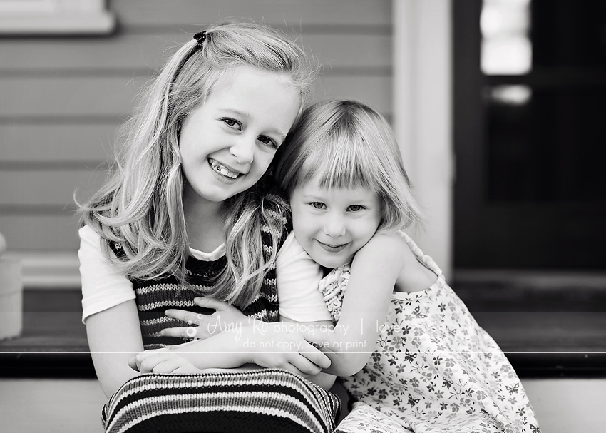 Black and white image of sisters sitting on stairs