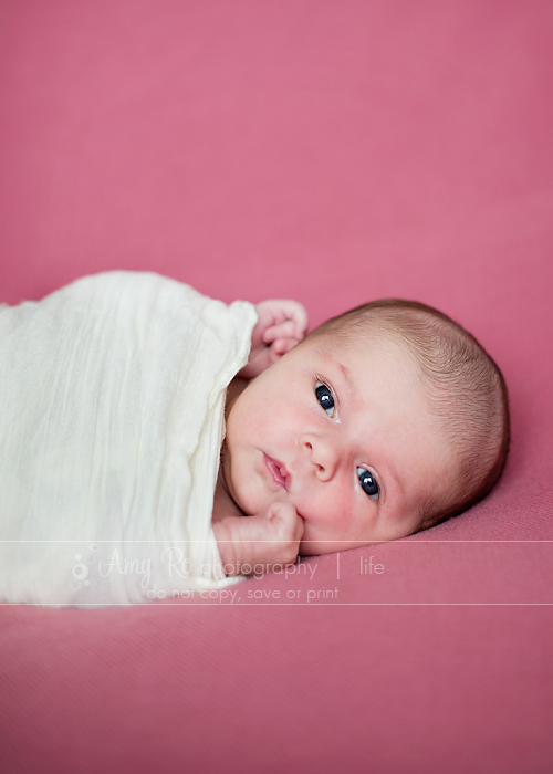 Awake newborn shot on pink blanket