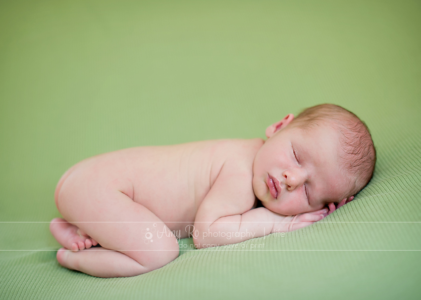 Newborn boy on green blanket