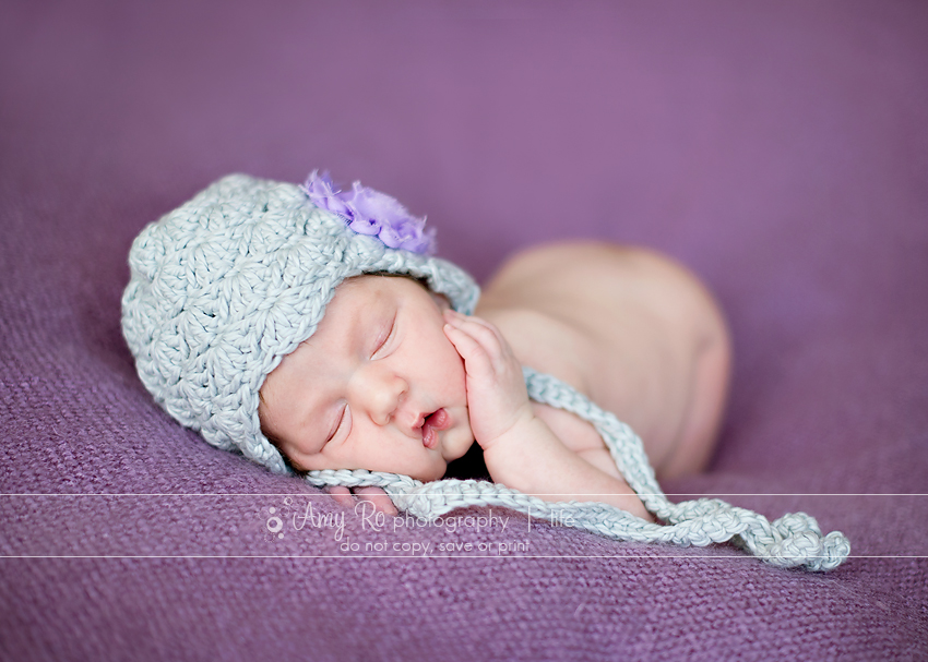 Providence newborn baby girl in grey hat on a purple blanket