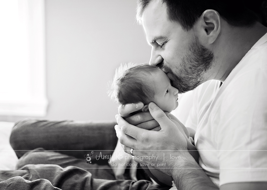 Black and white image of dad kissing newborn, Connecticut family photography