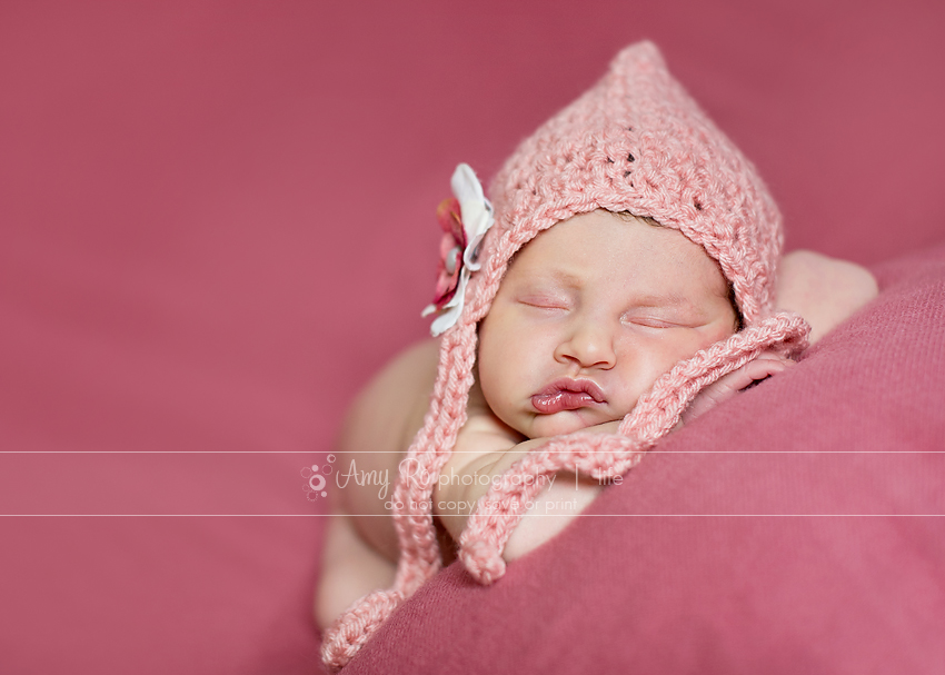 Newborn girl on pink blanket wearing a pink hat, Wrentham newborn photography