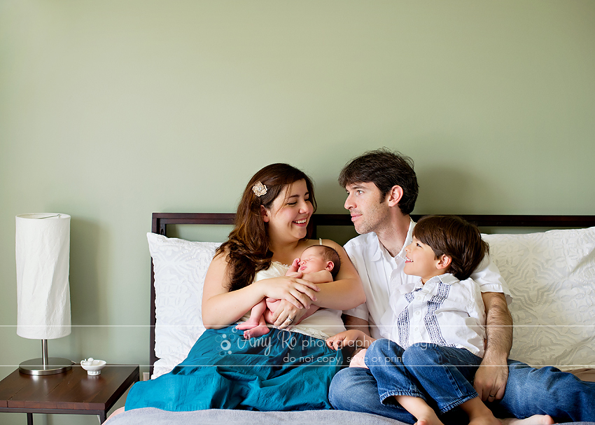 Family newborn shot on bed, sage green walls