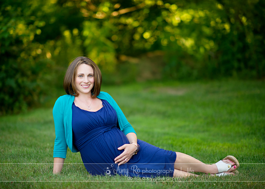 Mom sitting on grass during sunset lifestyle maternity portrait session in Rhode Island