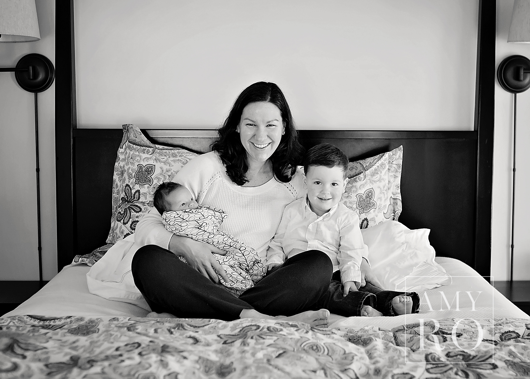 Black and white beautiful image of a mom with her toddler and newborn daughter taken during an in-home newborn photography session in Massachusetts