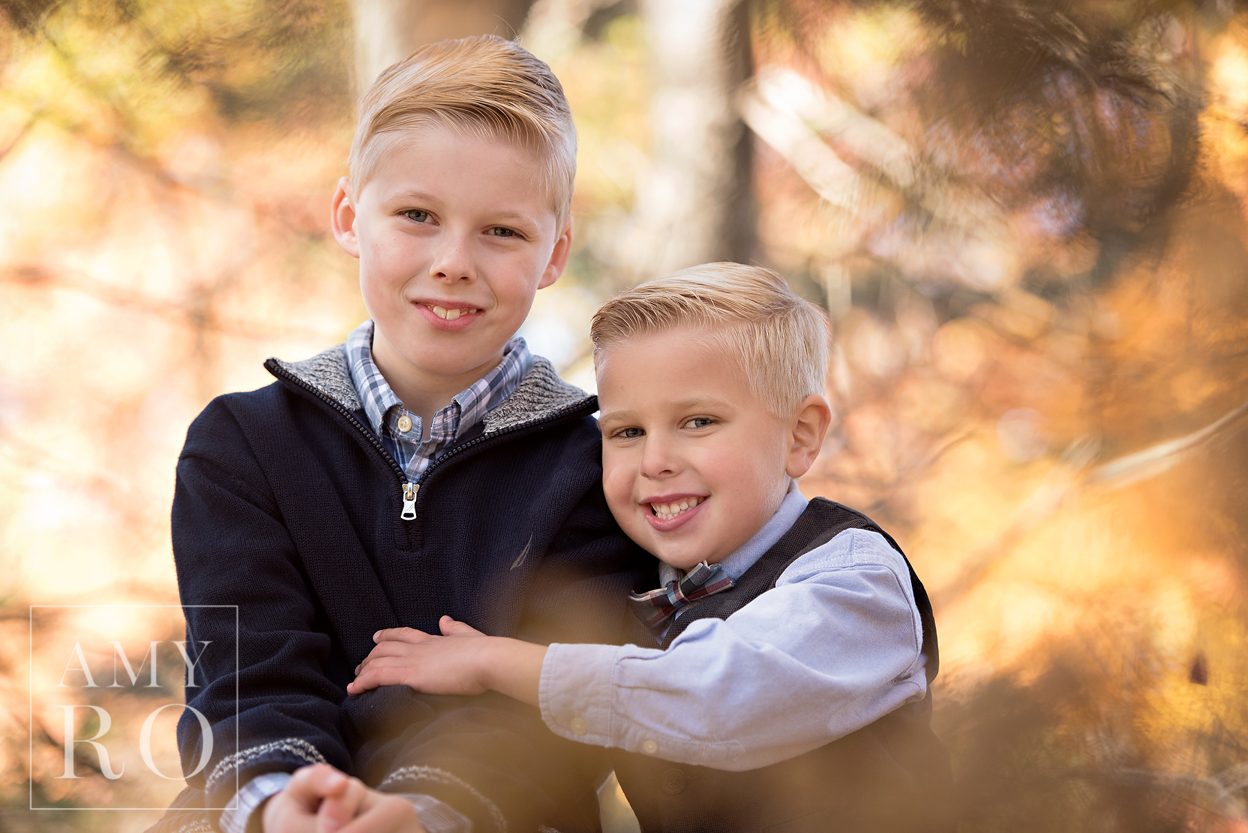 Image taken through the leaves of brothers in the fall in Rhode Island at a family photography session