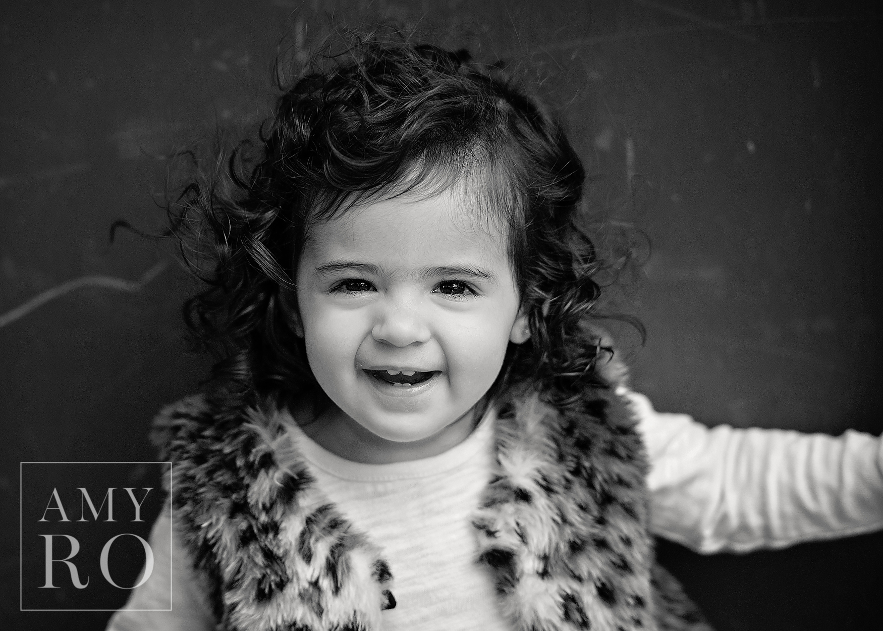 Black and white image of toddler girl laughing