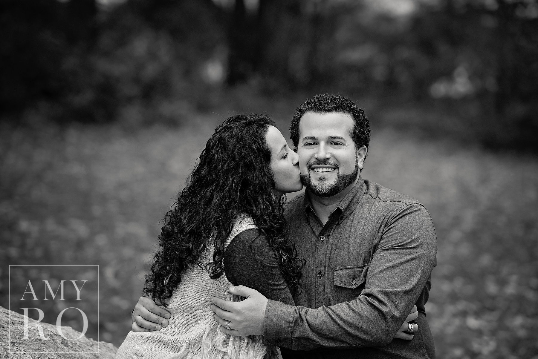 Black and white image of mom kissing dad during lifestyle session in Rhode Island