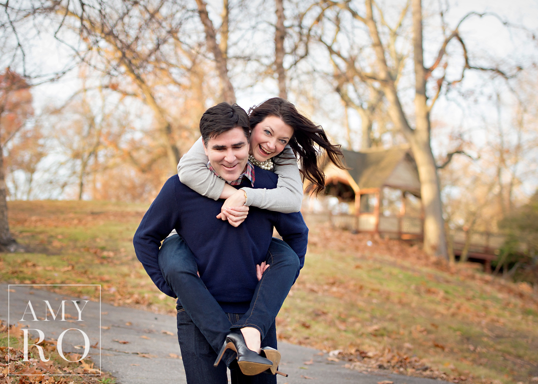 Color image of husband carrying his wife piggyback during fall family session in Rhode Island