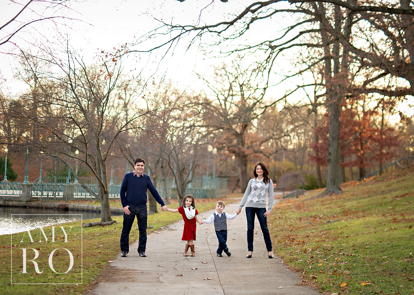 Family portrait in Roger Williams park on sidewalk standing holding hands.