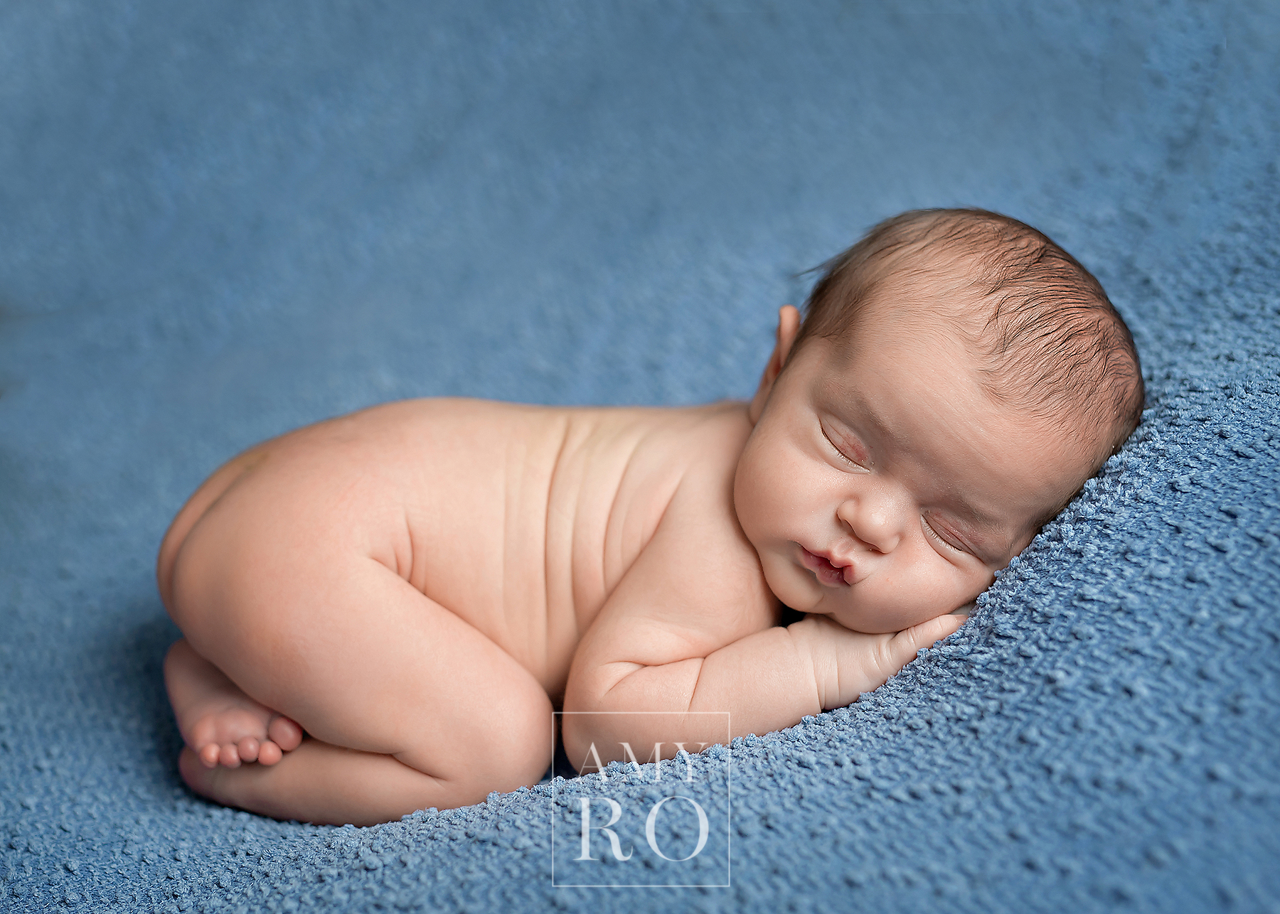 Newborn baby boy on blue blanket during a newborn photography session in Pawtucket, Rhode Island