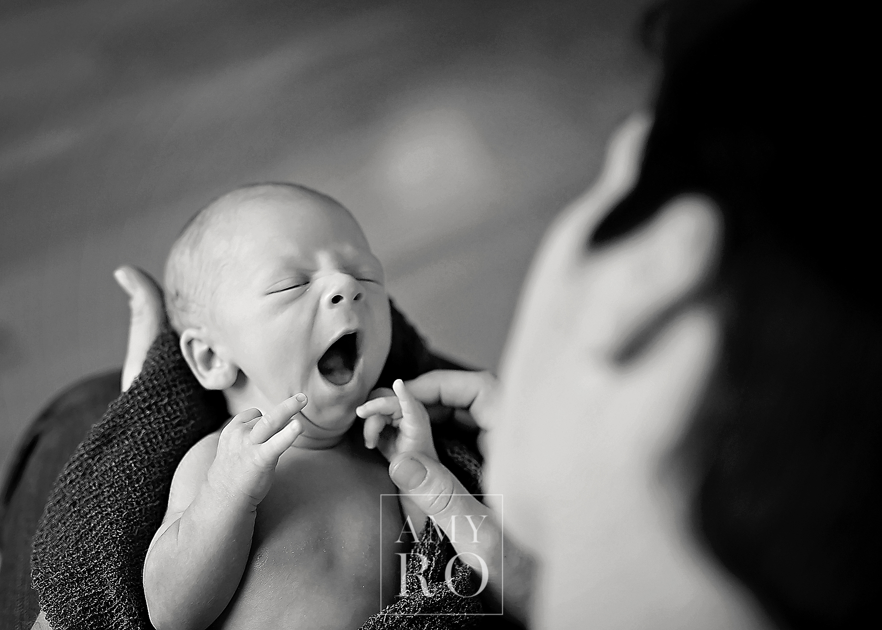 Black and white image of newborn yawning during in home newborn session in Massachusetts