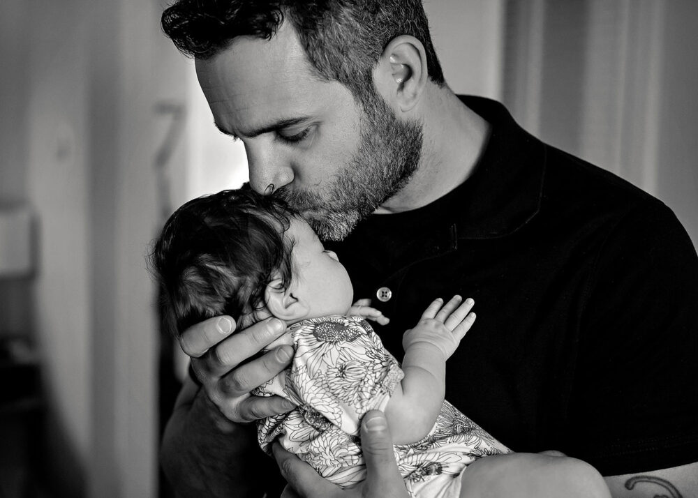 dad kissing baby during a newborn session in Rhode Island