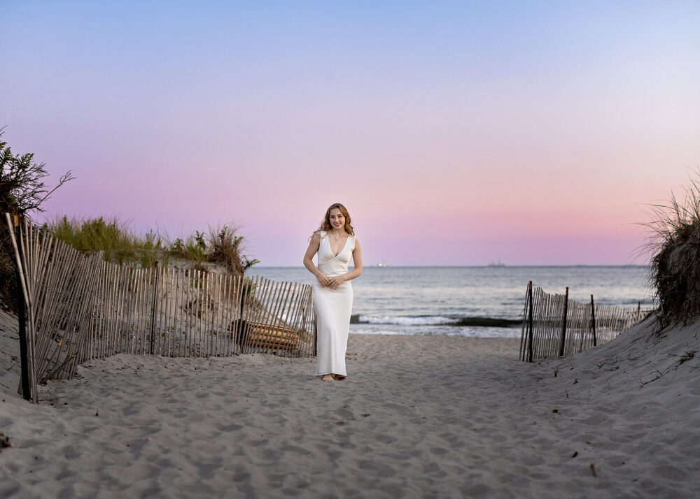 Senior girl in white gown on the sand at Sachuest Beach at sunset
