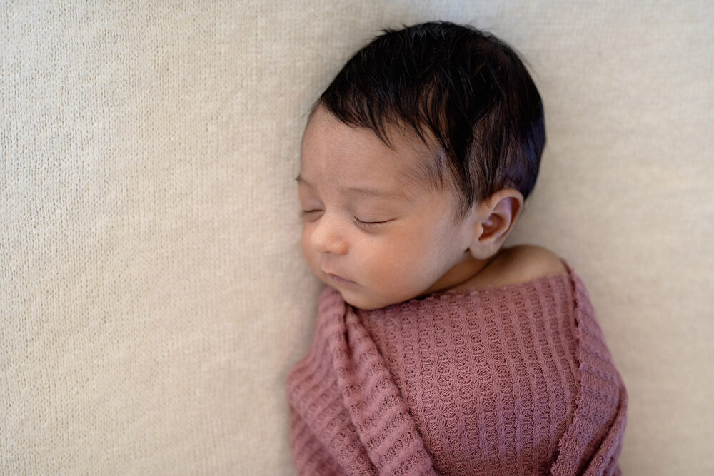 Baby swaddled in pink wrap in newborn photography session Massachusetts