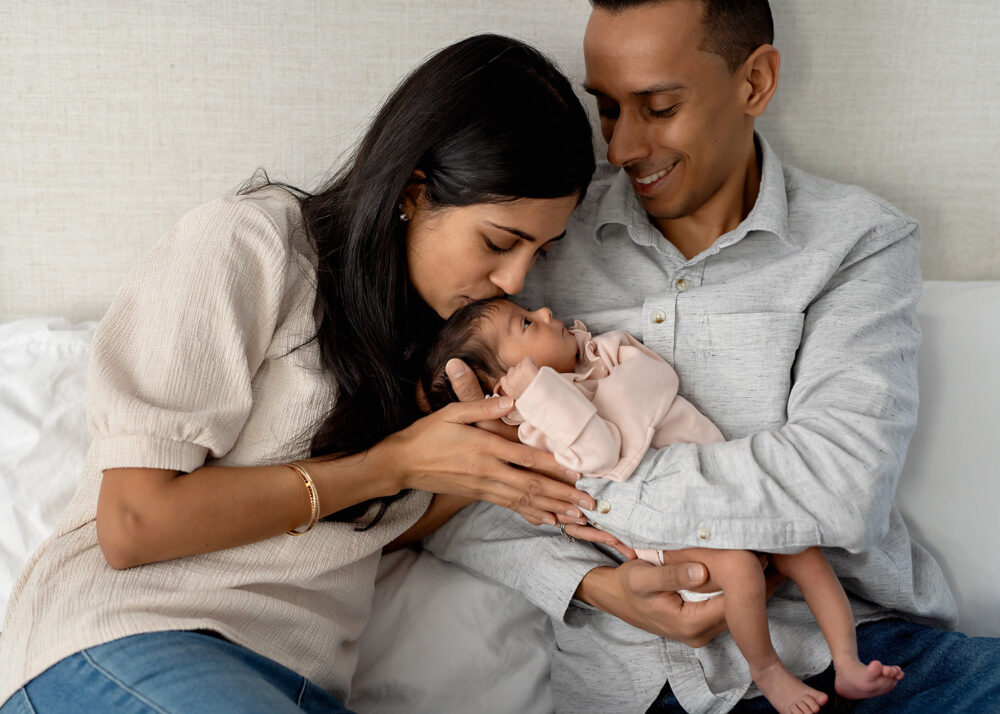 Close up image of mom and dad snuggling with newborn in home in Rhode Island