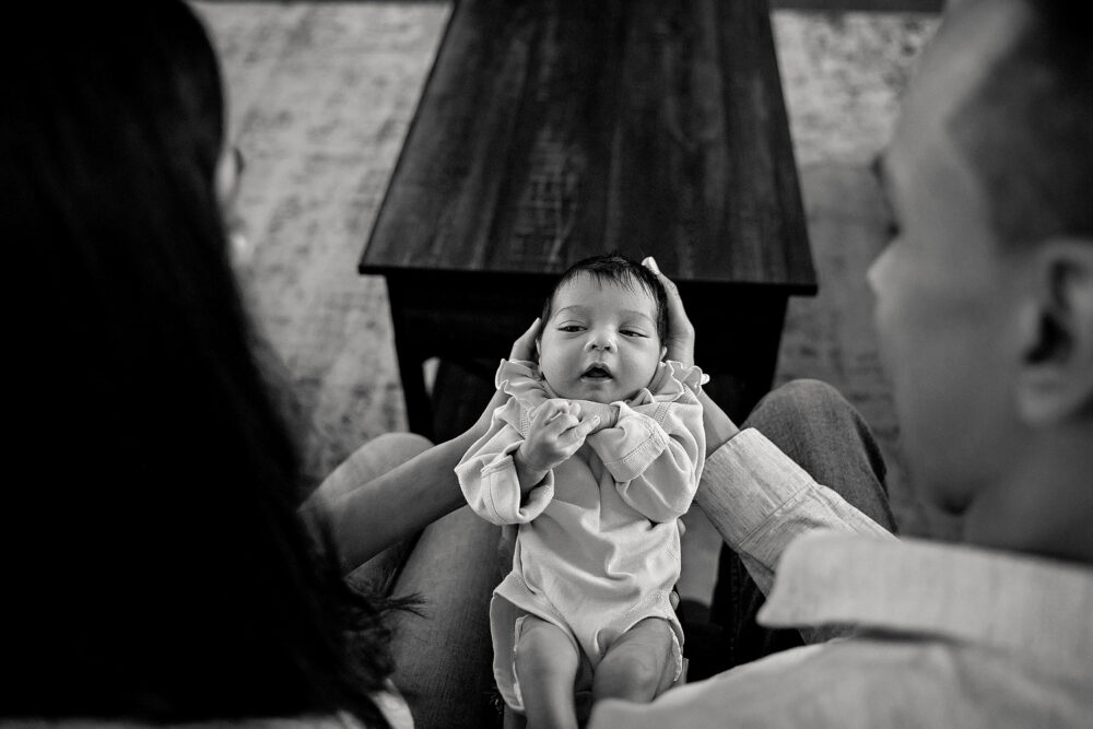 Over the shoulder baby during lifestlye newborn session in living room Rhode Island
