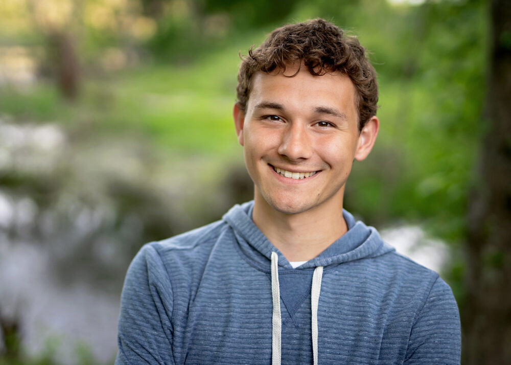 Smiling close up of senior in the woods in Rhode Island