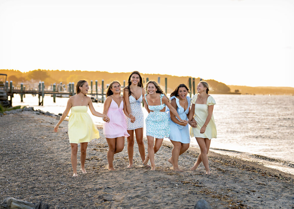 Walking group of senior girlfriends on the beach at sunset during session in summer Rhode Island