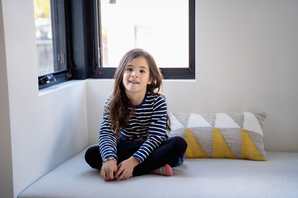 Big sister laughing on window seat near Barrington RI
