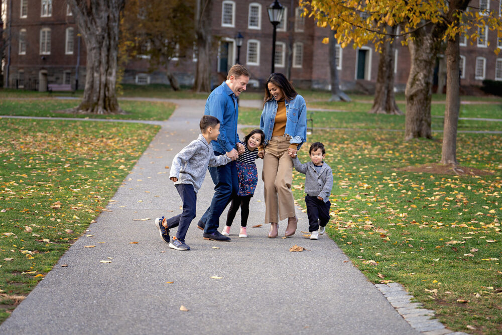 Laughing family walking brown's campus fall family session
