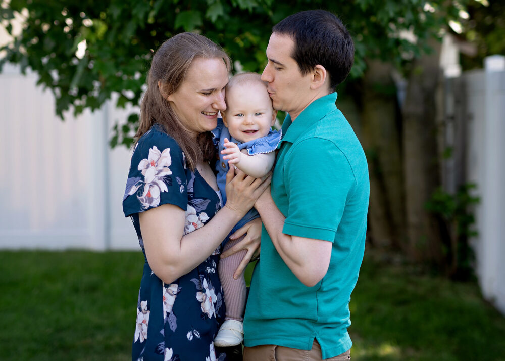 Mom and dad snuggling baby during photo session in Providene RI