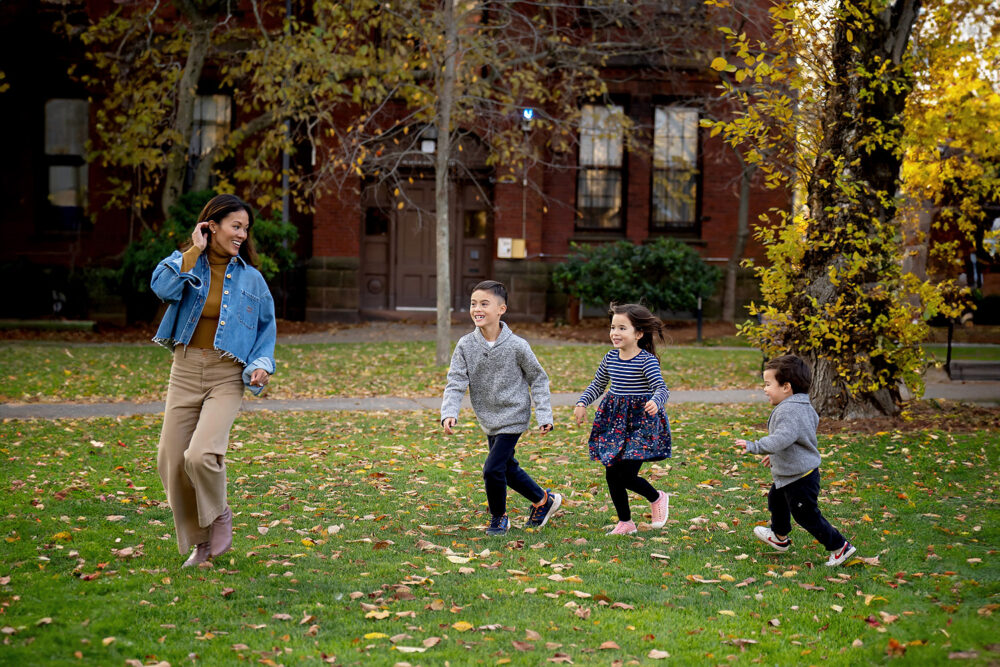 Mom and kids running in the grass Brown University family session