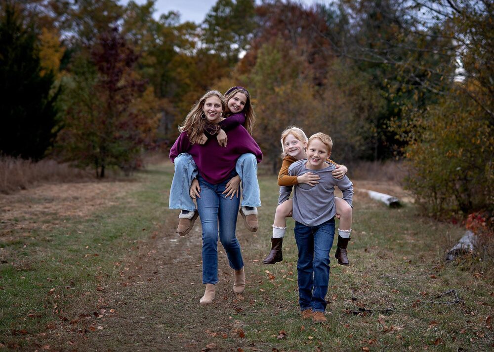Siblings doing piggyback running family photos in Shrewsbury Massachusetts