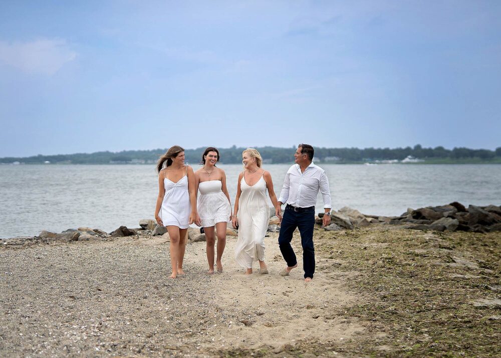 Family with teens walking on beach during family photos summer east greenwich Rhode Island