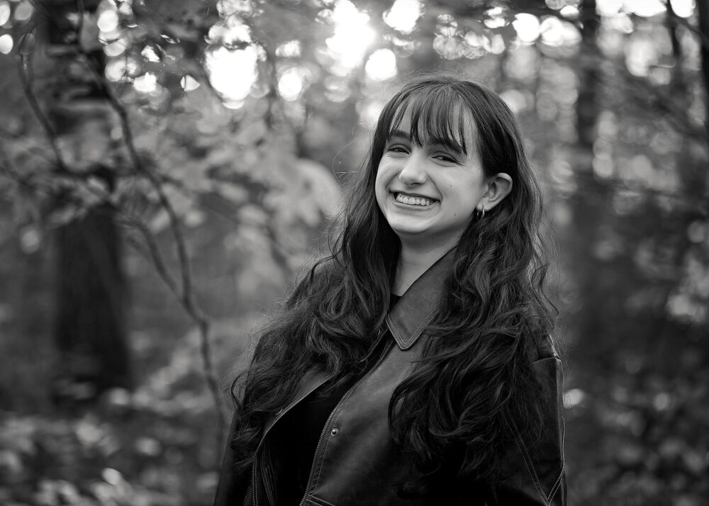 Senior girl with long hair laughing during senior photos in Cumberland Rhode Island