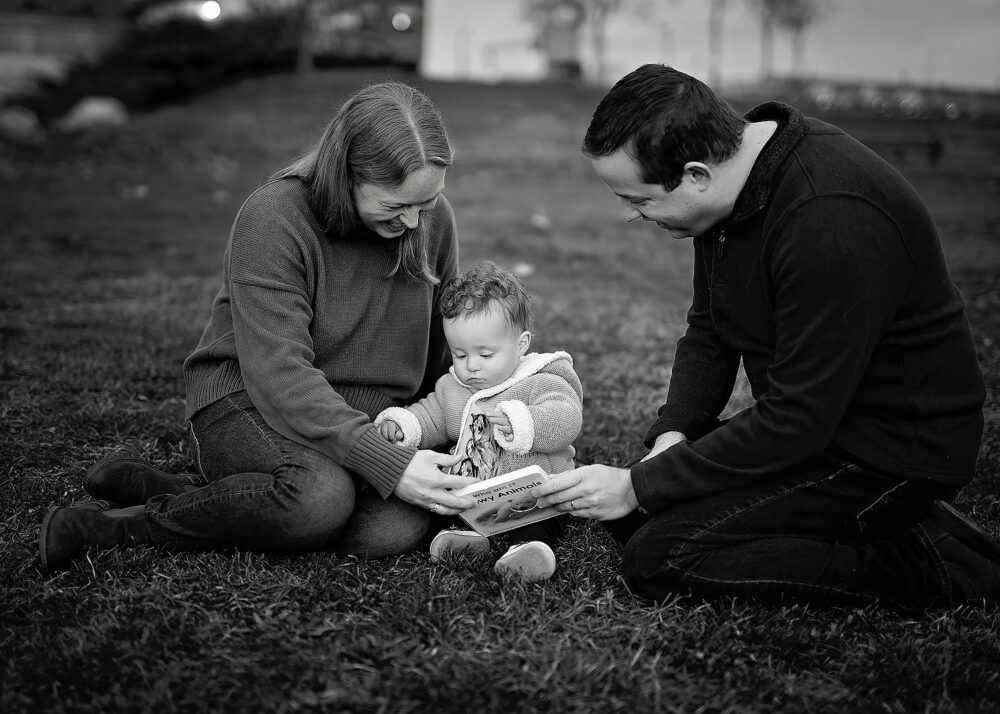 Family reading book with toddler during family photos in Providence